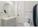 Bright bathroom featuring a gray vanity, a round mirror, white toilet, and tiled floors at 8410 Kenavis Pl, Odessa, FL 33556