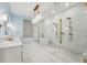 Bright bathroom featuring dual vanities, marble floors, bronze hardware, a glass enclosed shower, and soaking tub at 8410 Kenavis Pl, Odessa, FL 33556