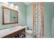 Charming bathroom with a framed mirror, decorative shower curtain, and tiled shower, offering a refreshing ambiance at 8410 Kenavis Pl, Odessa, FL 33556