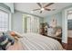 Serene bedroom with light walls, ceiling fan, adjacent bathroom, and stylish furniture, offers a cozy and inviting space at 8410 Kenavis Pl, Odessa, FL 33556