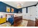 This bedroom features blue walls, two windows, a wooden bed frame, wood floors, and fun decor at 8410 Kenavis Pl, Odessa, FL 33556