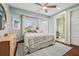 Light-filled bedroom boasts a ceiling fan, natural light, and an adjacent bathroom, creating a tranquil retreat at 8410 Kenavis Pl, Odessa, FL 33556