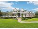 Stately two-story home with lush lawn, brick accents, covered porch, and beautiful gazebo at 8410 Kenavis Pl, Odessa, FL 33556