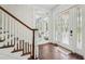 Bright foyer with hardwood floors, staircase, and decorative glass front door at 8410 Kenavis Pl, Odessa, FL 33556