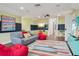 This stylish game room is painted with two-tone color with a colorful carpet, a TV, and cozy seating options at 8410 Kenavis Pl, Odessa, FL 33556