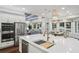 Open kitchen with island, stainless appliances, and breakfast bar overlooking the living and dining areas at 8410 Kenavis Pl, Odessa, FL 33556