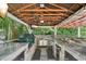 Well-equipped outdoor kitchen with a grill, counter space, stainless steel appliances, and a covered ceiling at 8410 Kenavis Pl, Odessa, FL 33556