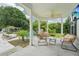 Inviting outdoor patio with comfortable seating, ceiling fan, and view of the lush backyard and pool at 8410 Kenavis Pl, Odessa, FL 33556