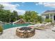 Backyard pool and spa area, featuring a fire pit, sun loungers, and a slide built into the rock feature at 8410 Kenavis Pl, Odessa, FL 33556