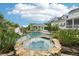 Luxurious pool and spa area with a rock waterfall, slide, and beautifully landscaped surroundings at 8410 Kenavis Pl, Odessa, FL 33556