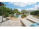 Resort style swimming pool with a sandy beach entry, slide, waterfall features, and lounge chairs at 8410 Kenavis Pl, Odessa, FL 33556