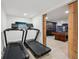 The workout room offers equipment and a glimpse into the game room, promoting fitness and fun at 8410 Kenavis Pl, Odessa, FL 33556
