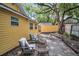 Backyard stone patio area with outdoor seating and lush, mature shade trees at 844 10Th S Ave, St Petersburg, FL 33701