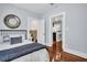 A bedroom with hardwood floors and a partial view into a bathroom, with a kitchen visible in the distance at 844 10Th S Ave, St Petersburg, FL 33701