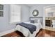 A bedroom with hardwood floors, a vintage mirror, and a doorway leading into a bathroom at 844 10Th S Ave, St Petersburg, FL 33701