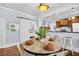 A dining area with a rustic table, chairs, and a plant centerpiece, leading to a kitchen and other rooms at 844 10Th S Ave, St Petersburg, FL 33701