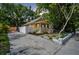 Charming yellow house with a inviting front porch, driveway, and mature trees at 844 10Th S Ave, St Petersburg, FL 33701