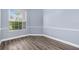 This bedroom features wood floors, soft blue walls, and a large window with exterior views at 8521 30Th E St, Parrish, FL 34219