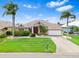 Charming front exterior with lush landscaping, mature palm trees, and well-manicured lawn at 8521 30Th E St, Parrish, FL 34219