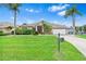 Charming single-story home featuring a lush green lawn, palm trees, and a welcoming front entrance at 8521 30Th E St, Parrish, FL 34219