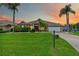 Charming single-story home at sunset featuring a lush green lawn, palm trees, and a welcoming front entrance at 8521 30Th E St, Parrish, FL 34219