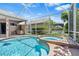 Inviting screened-in pool and spa area with an outdoor grill and lush landscaping at 8521 30Th E St, Parrish, FL 34219