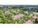 Aerial view of multi-Gathering townhomes surrounded by trees, neighborhood landscaping, and a small pond at 9418 W Park Village Dr # 105, Tampa, FL 33626