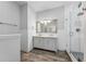 Bathroom with a dual sink vanity, framed mirrors, and a glass-enclosed shower at 9418 W Park Village Dr # 105, Tampa, FL 33626