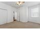 Bright bedroom features neutral carpet, ceiling fan, and natural light from a window at 9418 W Park Village Dr # 105, Tampa, FL 33626