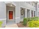 Townhome front entrance featuring covered porch, a red door, and neutral columns at 9418 W Park Village Dr # 105, Tampa, FL 33626