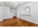 Open-concept living room with hardwood floors, white walls, and staircase view leading to the kitchen at 9418 W Park Village Dr # 105, Tampa, FL 33626
