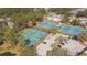 Aerial view of several blue and green tennis courts surrounded by mature trees at 9418 W Park Village Dr # 105, Tampa, FL 33626