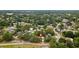 An aerial view of the property with a red marker indicating its location in a tree-filled neighborhood at 9602 N Rome Ave, Tampa, FL 33612