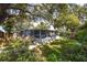 Picture-perfect backyard with lush greenery, a picket fence, and a charming screened-in porch at 10095 Oakhurst Rd, Seminole, FL 33776