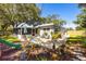 Inviting backyard featuring a screened-in porch, play equipment, and beautifully landscaped garden at 10095 Oakhurst Rd, Seminole, FL 33776