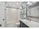 Clean bathroom with a tub, shower, modern fixtures, and vanity with a white marble top at 10095 Oakhurst Rd, Seminole, FL 33776