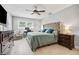 Relaxing bedroom with a large bed, wooden floors, a ceiling fan, and bright natural light at 10095 Oakhurst Rd, Seminole, FL 33776