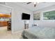 Comfortable bedroom featuring a ceiling fan, a large window, and views into the kitchen and hallway at 10095 Oakhurst Rd, Seminole, FL 33776