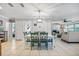 Bright dining area featuring a white table with green chairs and an open view of the living room fireplace at 10095 Oakhurst Rd, Seminole, FL 33776