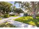 Exterior view of a single Gathering home with a large mature shade tree, a manicured lawn, and a concrete driveway at 10095 Oakhurst Rd, Seminole, FL 33776