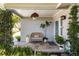Inviting front porch with cozy seating, lush greenery, and charming decor, creating a welcoming entrance at 10095 Oakhurst Rd, Seminole, FL 33776