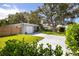 Well-maintained single Gathering home featuring a lush front lawn, mature trees, and a charming gray exterior at 10095 Oakhurst Rd, Seminole, FL 33776