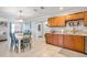 Open kitchen and dining area with tile floors, wood cabinets, and granite countertops at 10095 Oakhurst Rd, Seminole, FL 33776