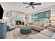 Cozy living room features a stone fireplace, comfortable seating, and a ceiling fan, creating a relaxing atmosphere at 10095 Oakhurst Rd, Seminole, FL 33776