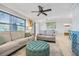 Inviting living room featuring comfortable seating, a ceiling fan, and large windows for natural light at 10095 Oakhurst Rd, Seminole, FL 33776