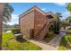 Brick apartment building with stairs leading to the second floor and beautiful landscaping at 10423 Carrollbrook Cir # 203, Tampa, FL 33618
