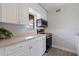 Well-lit kitchen with white cabinets, stainless steel appliances, and wood-look flooring at 10423 Carrollbrook Cir # 203, Tampa, FL 33618