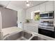 Modern kitchen with stainless steel appliances, white cabinets, and a view to the outside at 10423 Carrollbrook Cir # 203, Tampa, FL 33618