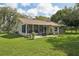 Backyard view of a home with a screened in patio, brick pavers and surrounding yard at 10614 Hudson Ave, Hudson, FL 34669