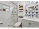 Updated bathroom with a glass door shower, modern star pattern tile, and vanity with a round mirror at 10614 Hudson Ave, Hudson, FL 34669